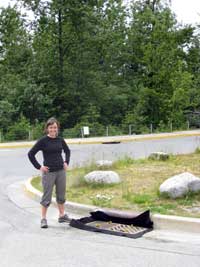 Jessi Carrier, JWP staff, shows off recently installed catch basin inserts